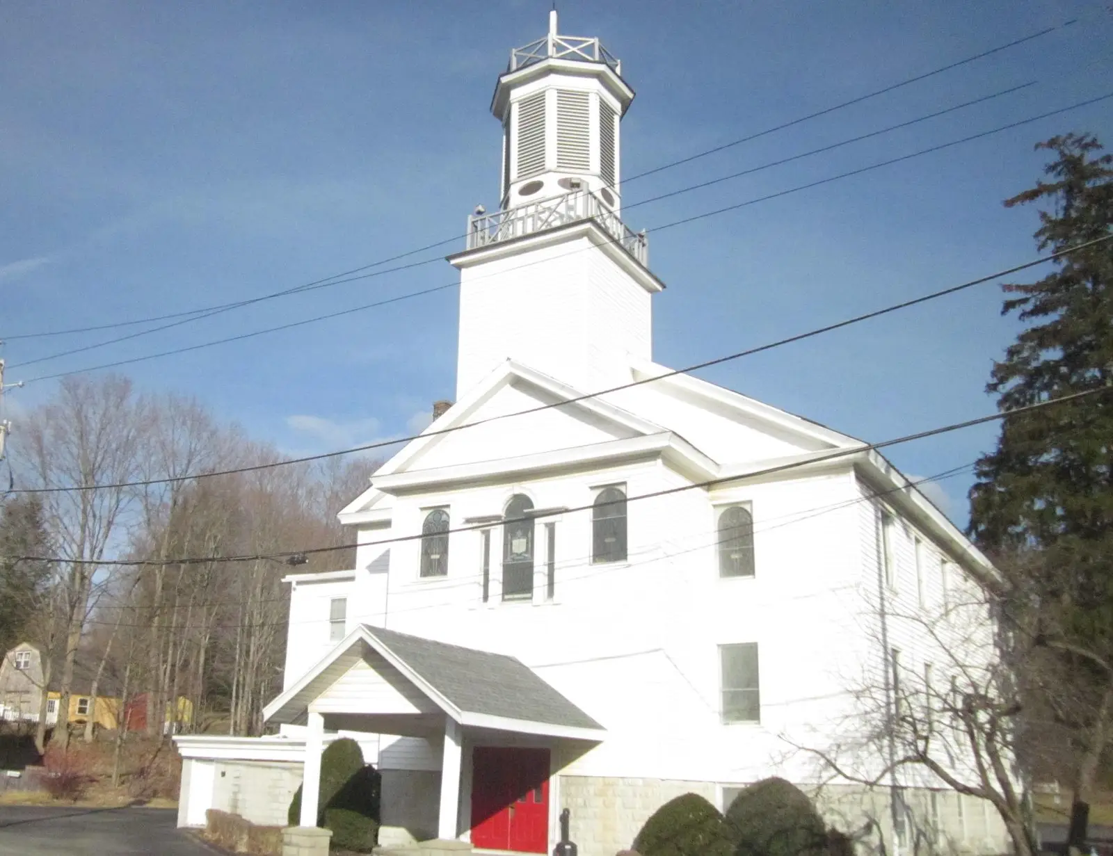 White clapboard church with a tall cupola and red doors in the hamlet of Wynantskill
